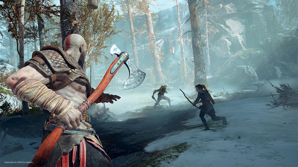Kratos holding the Leviathan Axe while Atreus faces an enemy in God of War (2018)